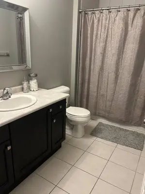 a bathroom with a sink and a toilet and a shower at Stunning House 4 bed 2.5 bath in Kitchener