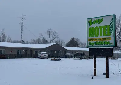 a sign in the snow in front of a building at Tay Motel in Waubaushene
