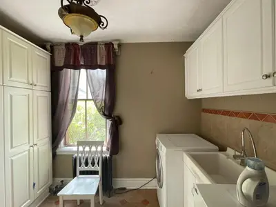 a kitchen with white cabinets and a window at THE RED HOUSE in Niagara Falls