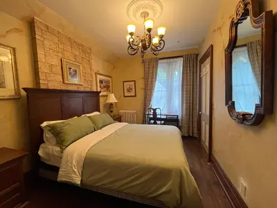 a bedroom with a large bed and a mirror at THE RED HOUSE in Niagara Falls
