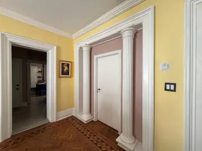 a hallway with yellow walls and white columns at THE RED HOUSE in Niagara Falls