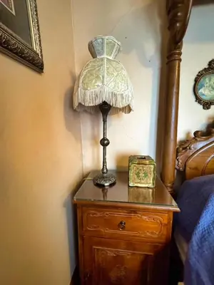 a lamp on a wooden dresser next to a bed at THE RED HOUSE in Niagara Falls