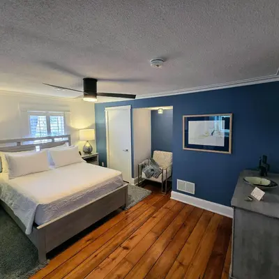 a bedroom with a bed and a blue wall at The Royal Manor Inn in Niagara on the Lake
