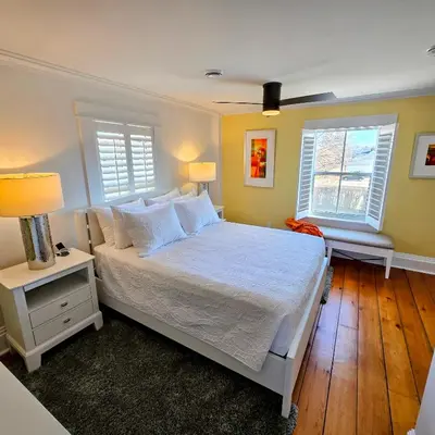 a bedroom with a white bed and two windows at The Royal Manor Inn in Niagara on the Lake