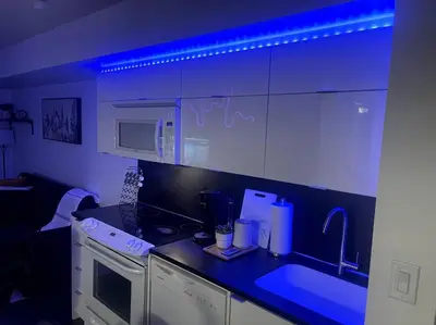 a kitchen with a sink and a stove and a microwave at SkyHigh Haven LED-Lit Downtown Condo Retreat in Toronto