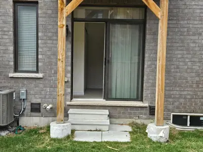 a house with two wooden poles in front of a door at Beautiful New Townhouse in Quiet Neighbourhood in Ajax