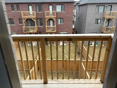 a balcony with a wooden fence and a building at Beautiful New Townhouse in Quiet Neighbourhood in Ajax
