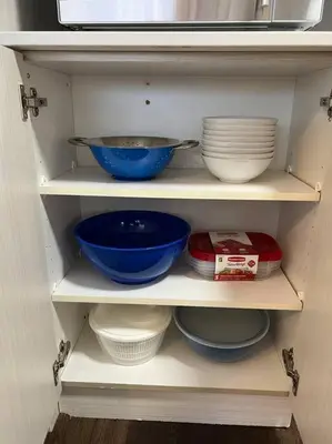 a cabinet filled with bowls and plates on shelves at Rustic Elegance & Style 1BR in London