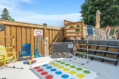 a backyard with a play area with chairs and a basketball hoop at Luxury Family Home in Burlington in Burlington