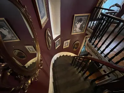 a spiral staircase in a building with portraits on the walls at THE RED dragon in Niagara Falls