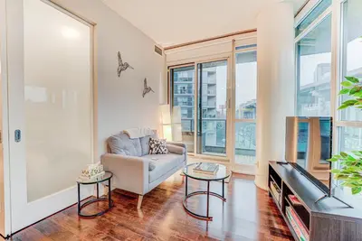 a living room with a couch and a tv at Prime City Pad 2 Bedroom with CN Tower View in Toronto