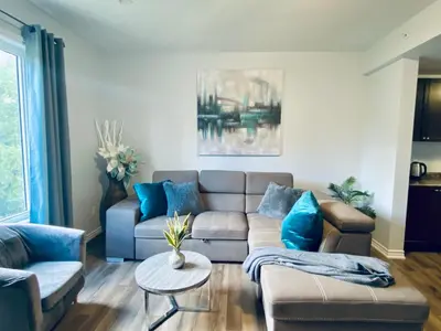 a living room with a couch and a table at Stylish 3 Bdrm house- king bed, Netflix, parking in Kitchener