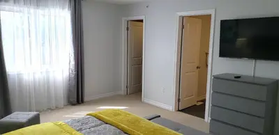 a bedroom with a bed and a tv and a dresser at Stylish 3 Bdrm house- king bed, Netflix, parking in Kitchener