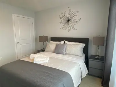 a bedroom with a bed with a clock on the wall at Stylish 3 Bdrm house- king bed, Netflix, parking in Kitchener