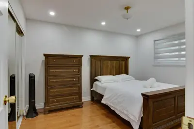 a bedroom with a large bed and a dresser at Beautiful House In Scarborough in Toronto