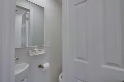 a white bathroom with a sink and a mirror at Beautiful House In Scarborough in Toronto