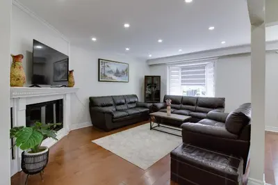 a living room with leather furniture and a fireplace at Beautiful House In Scarborough in Toronto