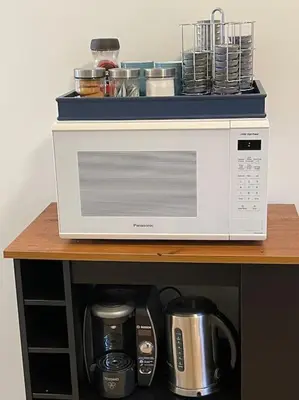 a microwave sitting on top of a wooden shelf at Vintage 2 bed 2 bath suite Distillery District in Toronto