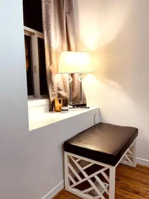 a stool sitting next to a window with a lamp at Vintage 2 bed 2 bath suite Distillery District in Toronto