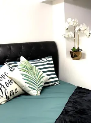 a black couch with pillows and a vase with flowers at Vintage 2 bed 2 bath suite Distillery District in Toronto