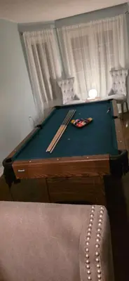a pool table with two cuesticks on top of it at short time rental in Kawartha Lakes