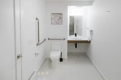 a white bathroom with a toilet and a sink at Stay Inn Muskoka in Gravenhurst
