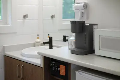 a bathroom with a sink and a coffee maker on a counter at Stay Inn Muskoka in Gravenhurst