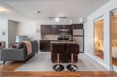 a living room with a kitchen and a couch at Spacious 2 Bedroom plus Den, 2 Bath, Sleeps 5 with Balcony and Lakeview Downtown Toronto Condo in Toronto