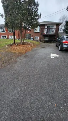 a car parked in a parking lot in front of a house at Newly Furnished Modern Apartment in Welland