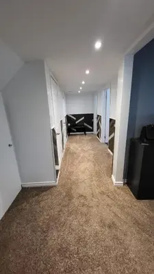 an empty room with a couch in a room with white walls at Newly Furnished Modern Apartment in Welland