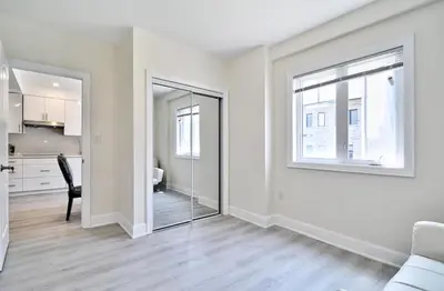 an empty living room with a glass door leading to a kitchen at 50% discount Amazing 3 Bedrooms Guest Suite in Richmond Hill