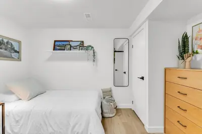 a bedroom with a bed and a dresser and a mirror at Bright 2-Bedroom Apartment in Burlington