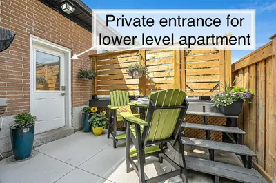 a patio with two green chairs and a table at Bright 2-Bedroom Apartment in Burlington