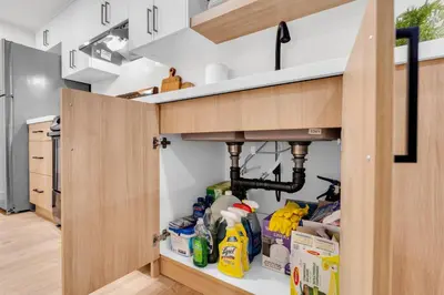 a kitchen with an open pantry with cleaning supplies at Bright 2-Bedroom Apartment in Burlington