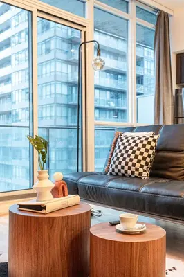 a living room with a black couch and a table at GSuite Express Downtown Toronto in Toronto