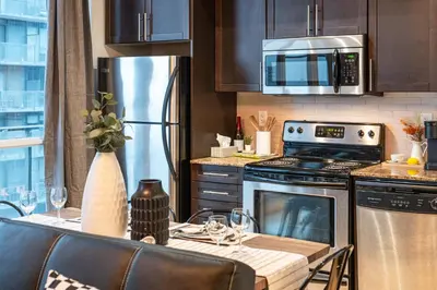 a kitchen with a table with a stove top oven at GSuite Express Downtown Toronto in Toronto