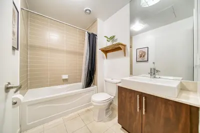 a bathroom with a sink and a toilet and a bath tub at GSuite Express Downtown Toronto in Toronto