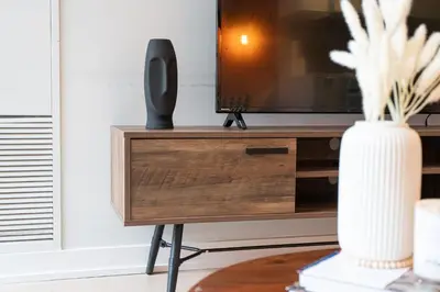 a television on a stand with a vase at Stylish Downtown Toronto Suite with Free Parking in Toronto