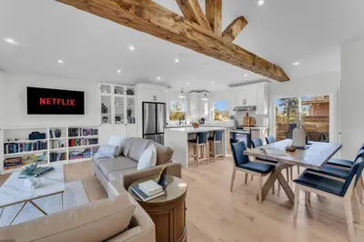 a living room with a couch and a table at Spacious Elegance: Two Living Spaces in One Home in Burlington