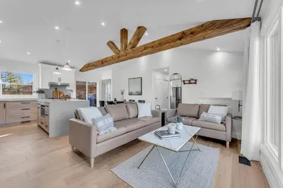 a living room with a couch and a table at Spacious Elegance: Two Living Spaces in One Home in Burlington