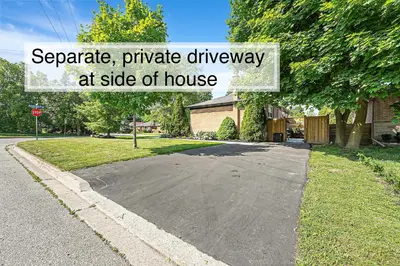a driveway with a sign that reads separate private driveway at side of house at Spacious Elegance: Two Living Spaces in One Home in Burlington