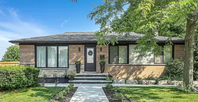 a brick house with a front door and stairs at Spacious Elegance: Two Living Spaces in One Home in Burlington