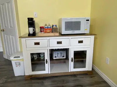 a microwave sitting on top of a white cabinet at Private Suite in Niagara Falls in Niagara Falls