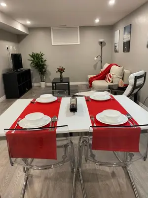 a living room with a table with red chairs at Brand new apartment with private entrance and patio in Guelph