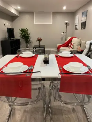 a dining room with red chairs and a table at Brand new apartment with private entrance and patio in Guelph