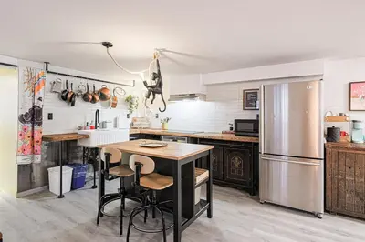 a kitchen with a wooden table and a refrigerator at Spa Oasis in Toronto's Heart-Free Parking! and Pet Friendly in Toronto