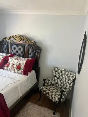 a bedroom with a bed and a chair at Queen’s Gate Ecstasy Home in Brampton
