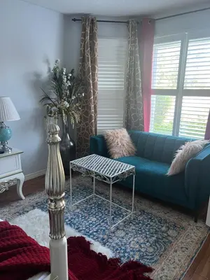 a living room with a blue couch and a table at Queen’s Gate Ecstasy Home in Brampton