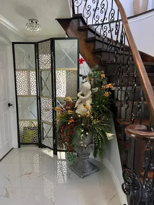 a staircase with a vase with flowers on it at Queen’s Gate Ecstasy Home in Brampton