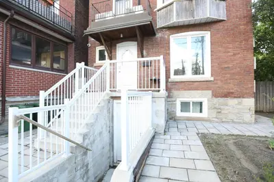 a white staircase leading up to a brick building at Xiao Wang in Toronto